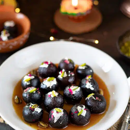 Kala Gulab Jamun in a plate garnished with edible silver foil