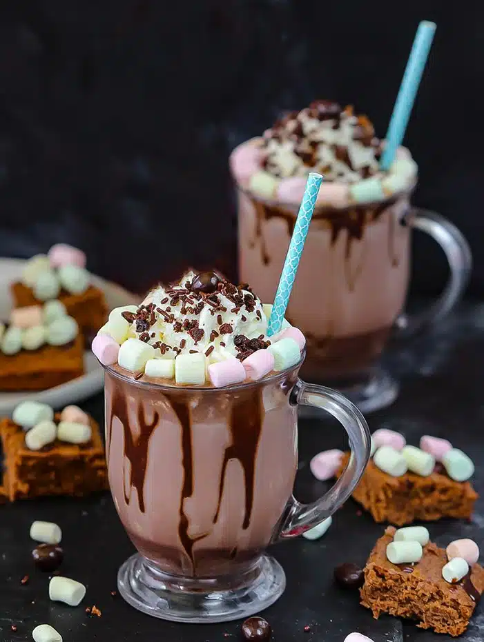 Frozen Hot Chocolate with brownie pieces and marshmallows in background