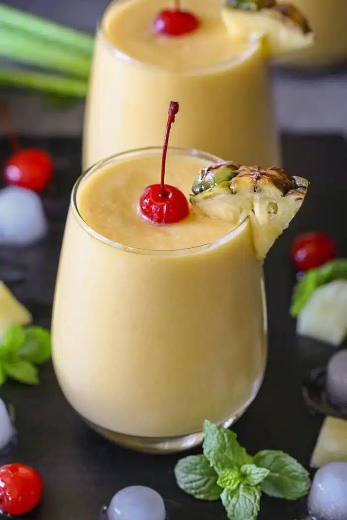 Pineapple Mango Piña Colada in a glass garnish with cherry